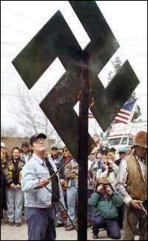 ANTIGREEN FERVOR: John Stokes, a Kalispell, Mont., radio host, lit a green swastika on fire at an 'anti-Earth Day' rally he helped organize.
Photo by Robin Loznak