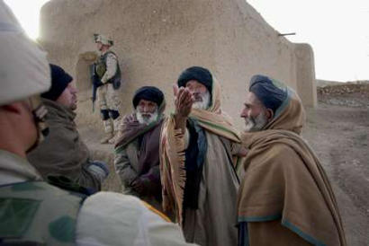 A civil affairs officer from the 82nd Airborne interviews Engran village elders. [Reuters photo/David Swanson] 